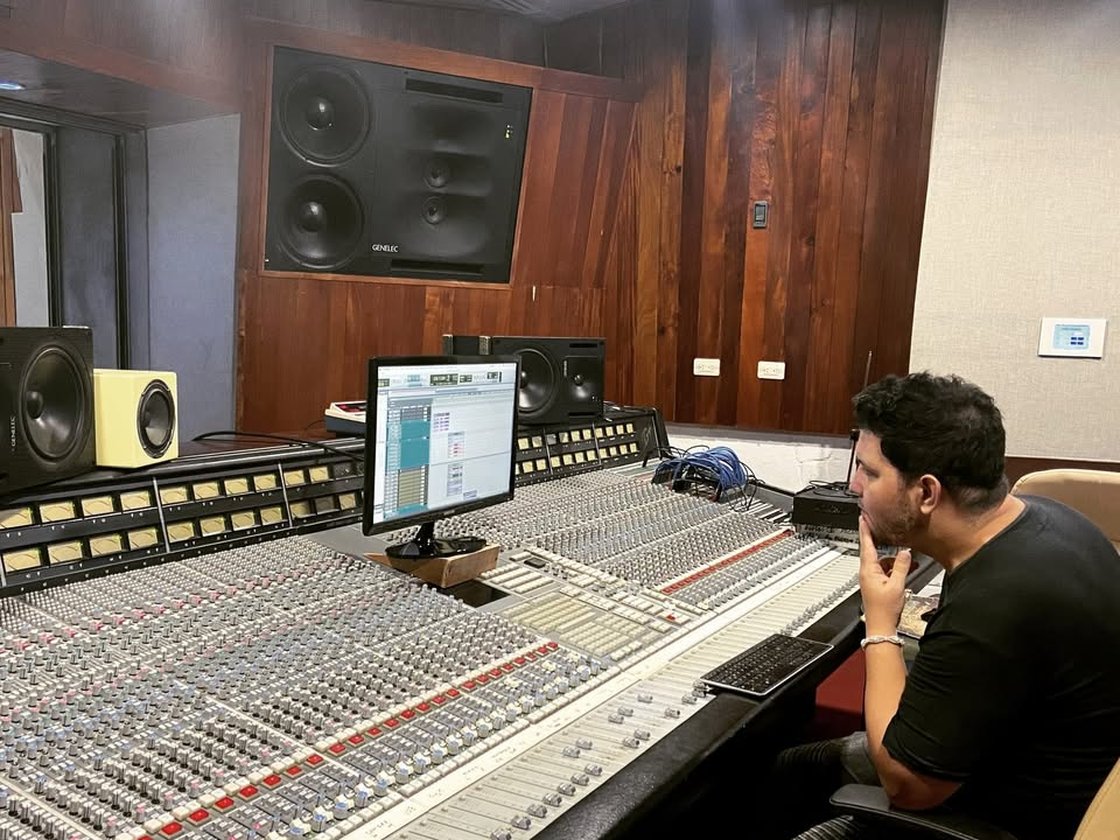Miguel Rosales escuchando una mezcla en una sala de control con monitores Genelec