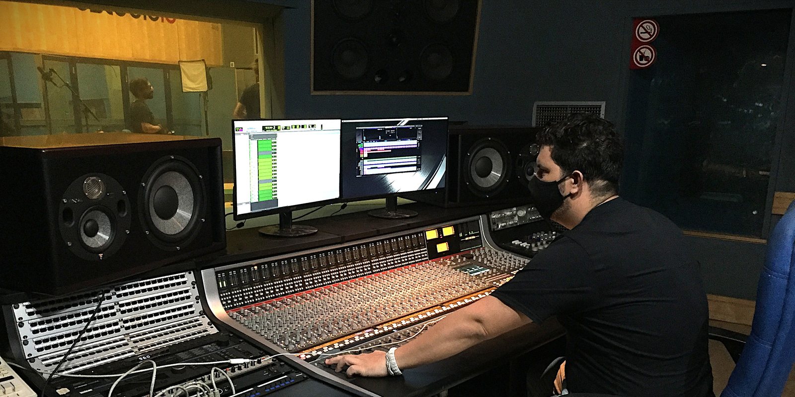 Miguel Rosales mezclando en una consola analógica de formato grande durante una sesión de grabación